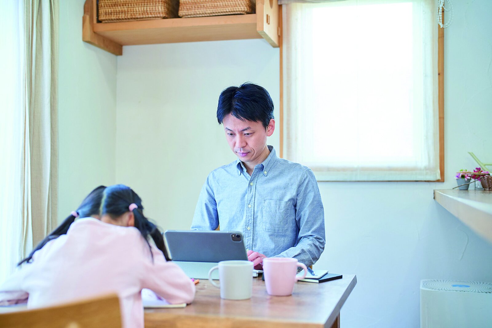 在宅で子どもと過ごしながらタブレットを使って仕事をする様子